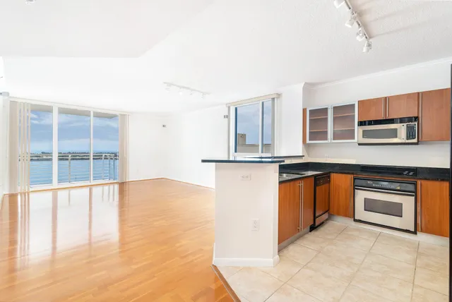 a kitchen with stainless steel appliances granite countertop a stove and a sink with cabinets