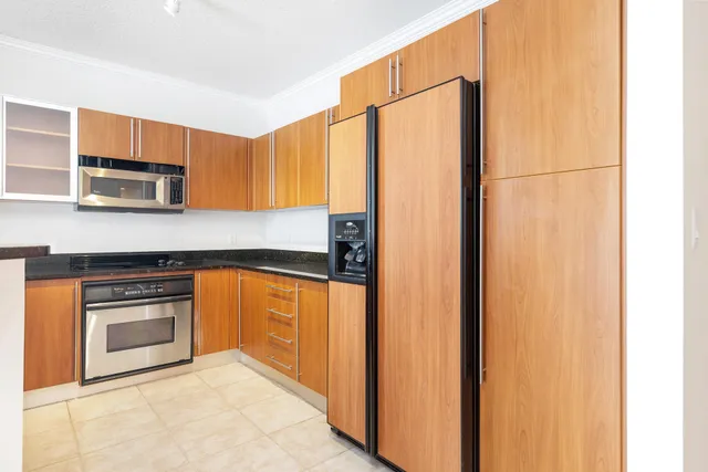 a kitchen with stainless steel appliances granite countertop a refrigerator a stove and a microwave