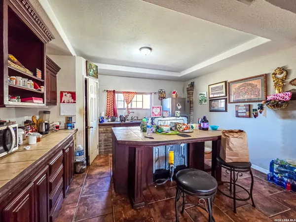 a room with stainless steel appliances lots of wooden furniture a dining table and chairs in it