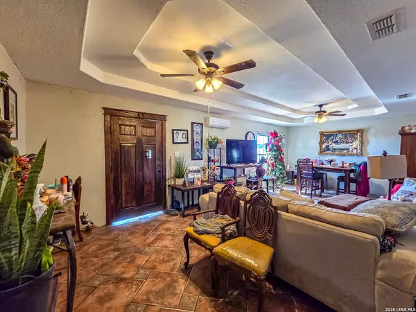 a living room with furniture a chandelier fan and a window