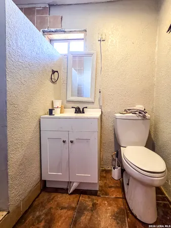 a bathroom with a toilet a sink and mirror