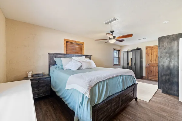 a bedroom with a bed wooden floor and window