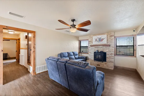 a living room with furniture a fireplace and a ceiling fan