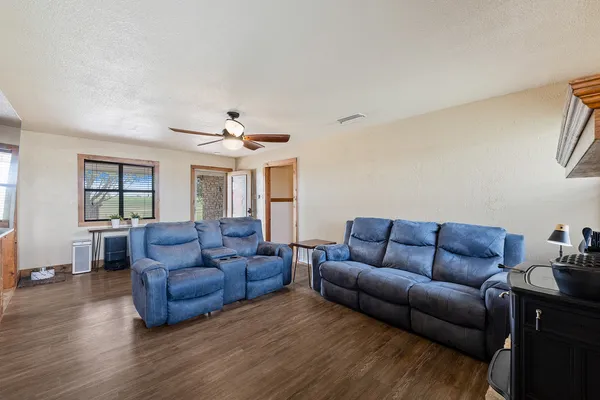 a living room with furniture and a wooden floor