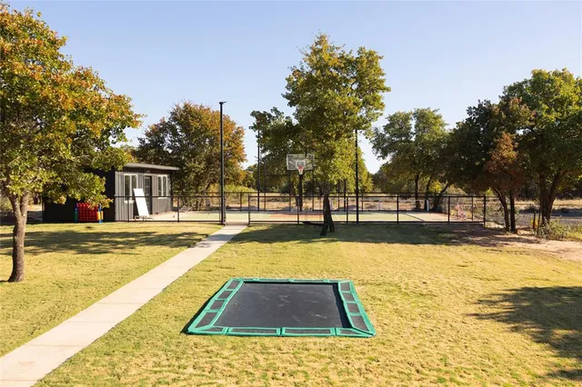 a view of swimming pool with outdoor seating and trees in the background