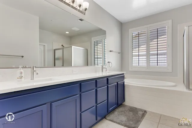 a bathroom with double vanity sinks and a bathtub