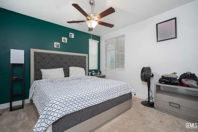 a bedroom with a bed and ceiling fan