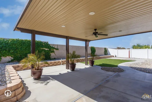 a view of a patio with a table and chairs under an umbrella