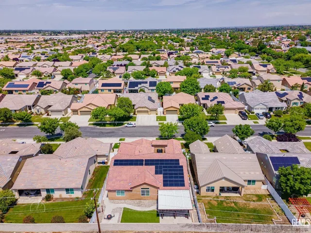 an aerial view of residential houses with outdoor space and parking