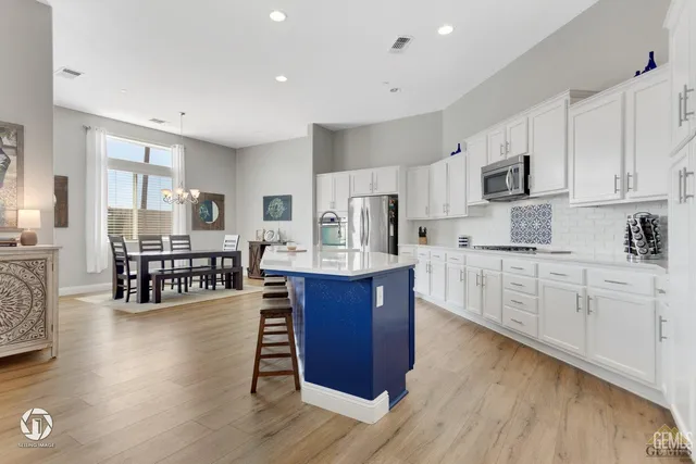 a large kitchen with stainless steel appliances wooden floors and wooden cabinets