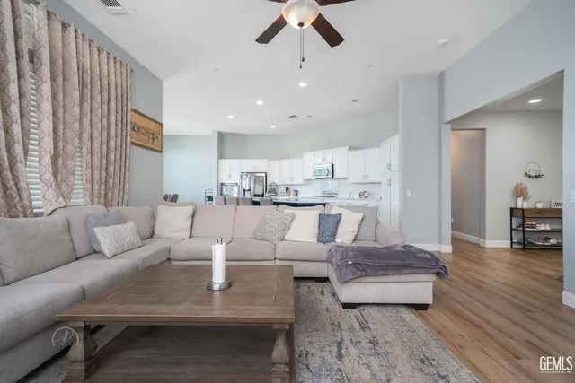 a living room with furniture and a view of kitchen