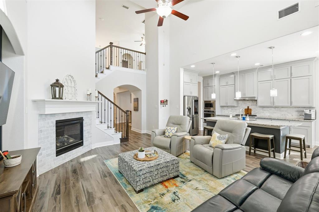6371 Whiskerbrush Road Flower Mound, TX 76226 - Photo 3 of 38 Dramatic double-height family room, featuring an anchored fireplace and a stunning staircase.