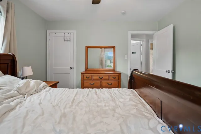 a bedroom with a bed and dresser with mirror
