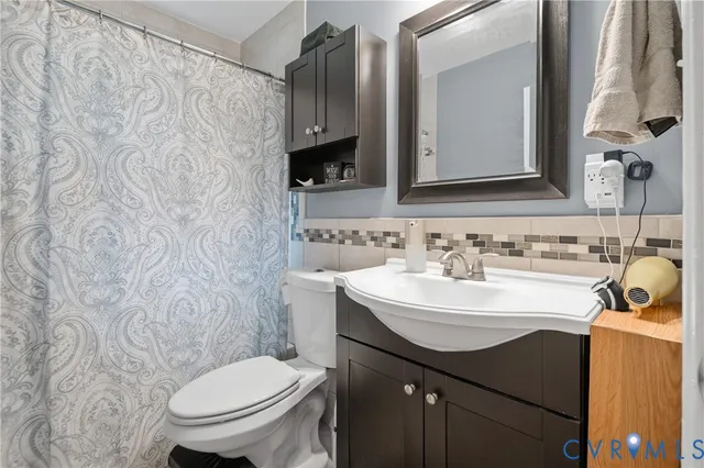 a bathroom with a sink vanity mirror and toilet