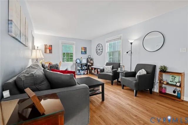 a living room with furniture and a wooden floor
