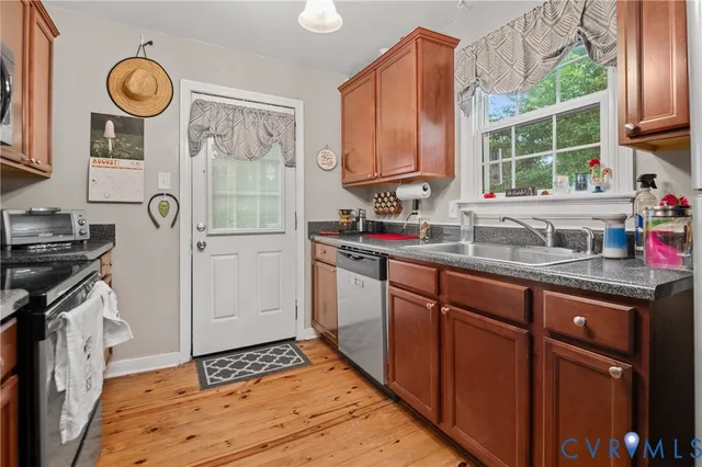a kitchen with granite countertop cabinets a stove a sink and a window