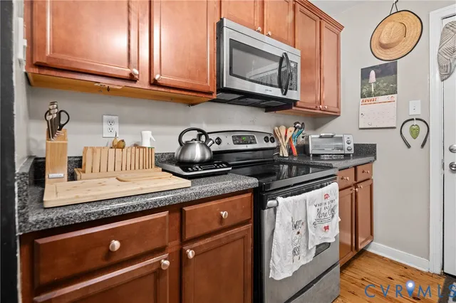 a kitchen with stainless steel appliances granite countertop a sink a stove and cabinets