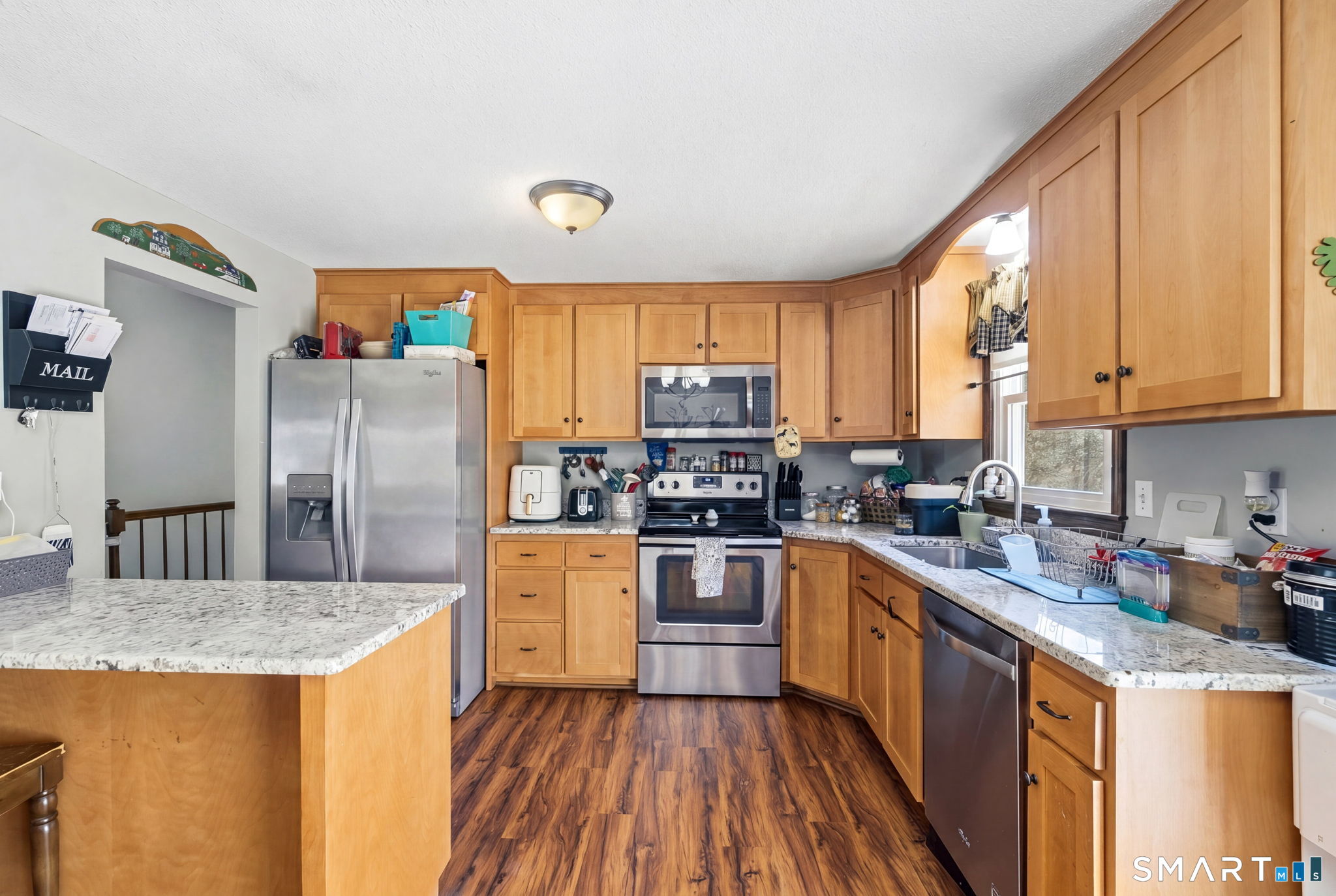 264 Quaddick Town Farm Road Thompson, CT 06277 - Photo 14 of 35 a kitchen with stainless steel appliances granite countertop a stove a sink dishwasher a refrigerator and cabinets with wooden floor