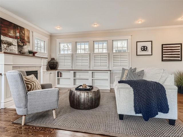 a living room with furniture a large window and a fireplace