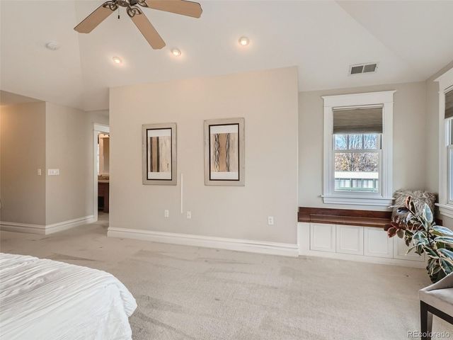 a spacious bedroom with a bed and a chandelier