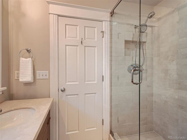 a bathroom with a granite countertop sink a shower and a mirror