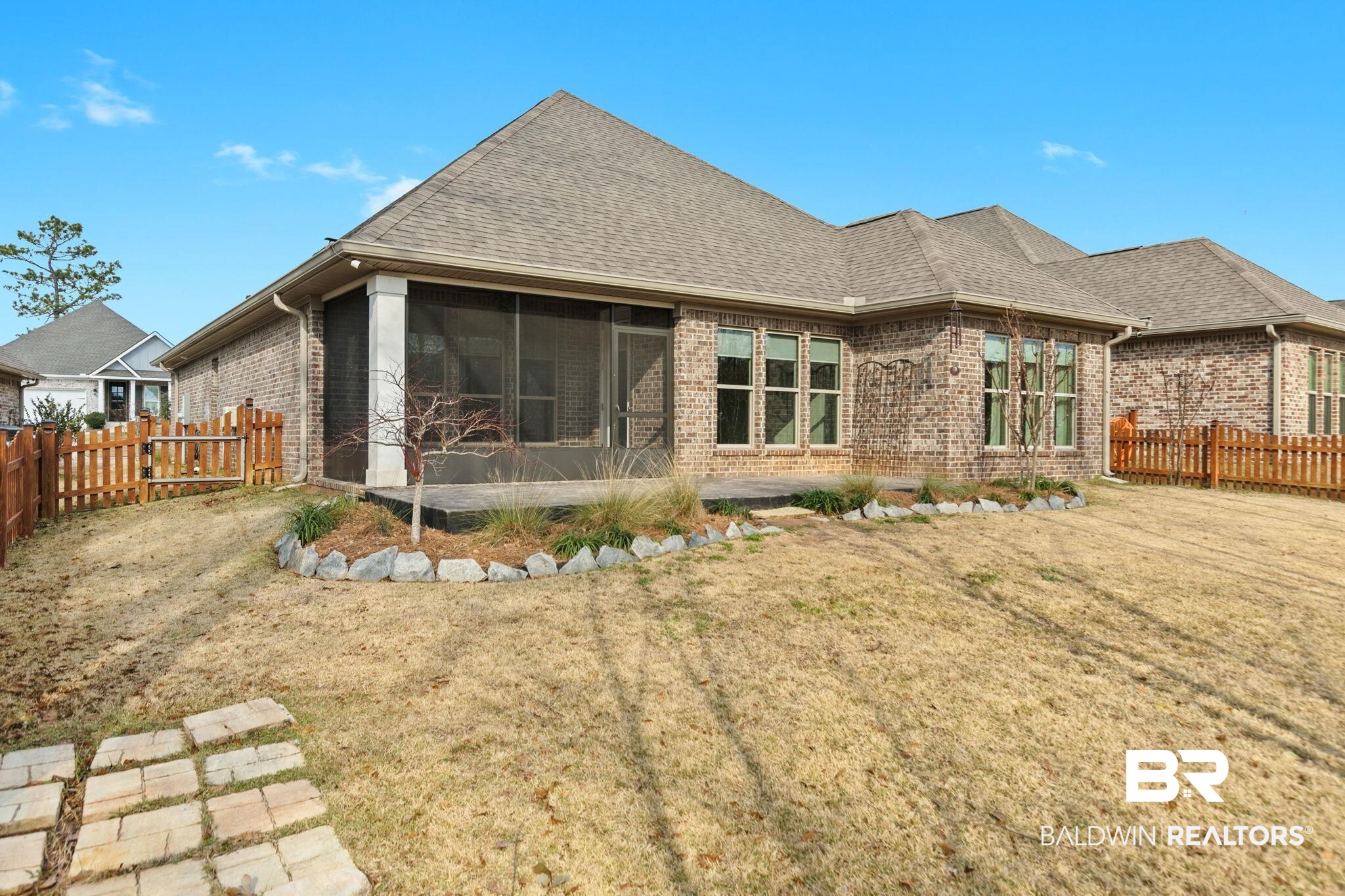 31654 Canopy Loop Daphne, AL 36527 - Photo 53 of 64 Rear view of house with a fenced backyard, a sunroom, roof with shingles, and brick siding