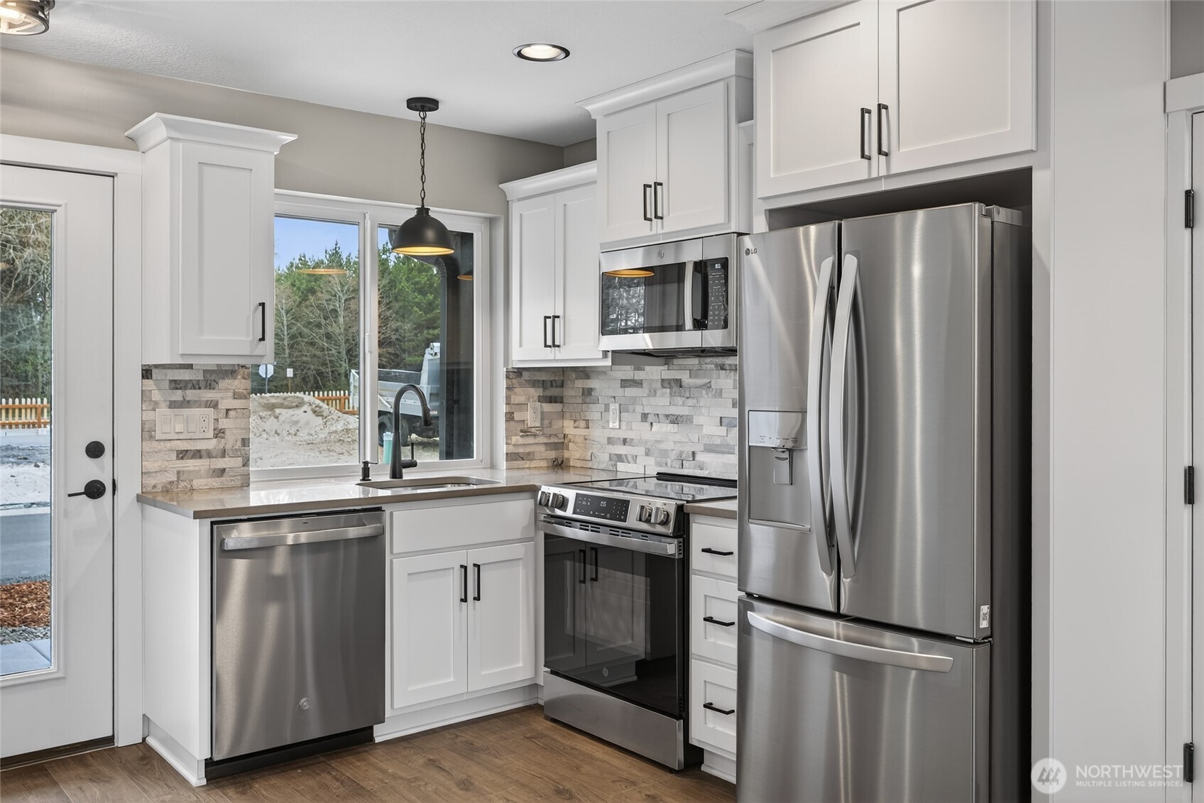 109 7th Street Southwest Long Beach, WA 98631 - Photo 7 of 22 a kitchen with stainless steel appliances a refrigerator sink and microwave
