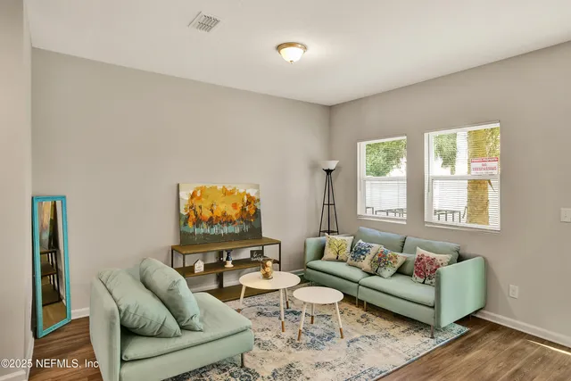 a living room with furniture a rug and a window