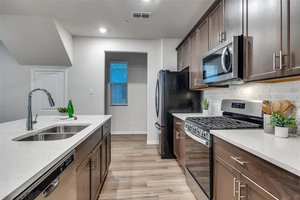 a kitchen with stainless steel appliances granite countertop a sink stove and refrigerator
