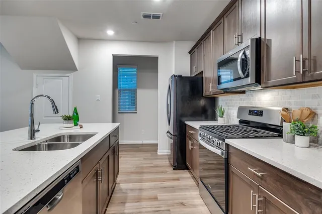 a kitchen with stainless steel appliances granite countertop a sink stove and refrigerator