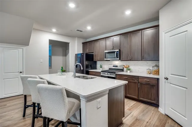 a kitchen with kitchen island a sink counter and chairs