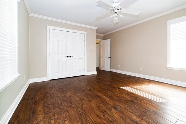 a view of empty room with wooden floor and fan