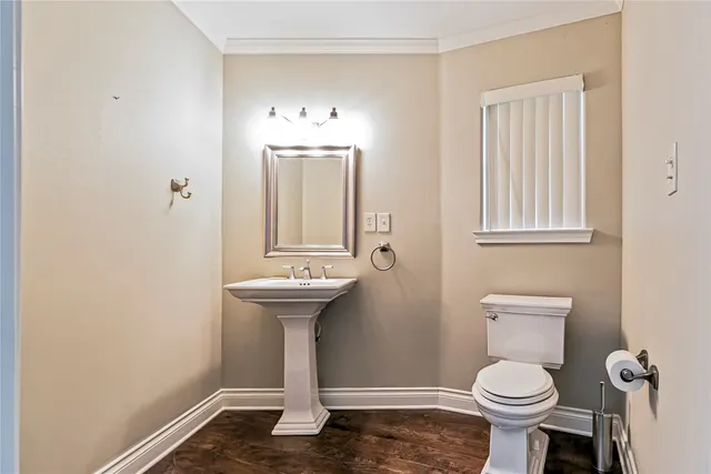 a bathroom with a sink a toilet and a window