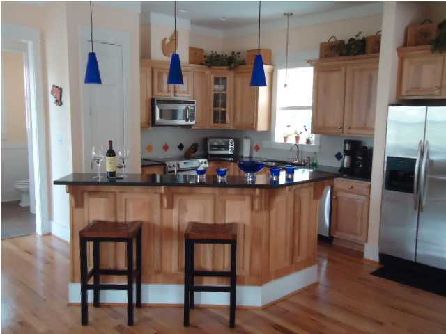 120 Seacrest Beach Blvd Inlet Beach Inlet Beach, FL 32461 - Photo 6 of 31 a kitchen with stainless steel appliances granite countertop a table chairs sink and cabinets