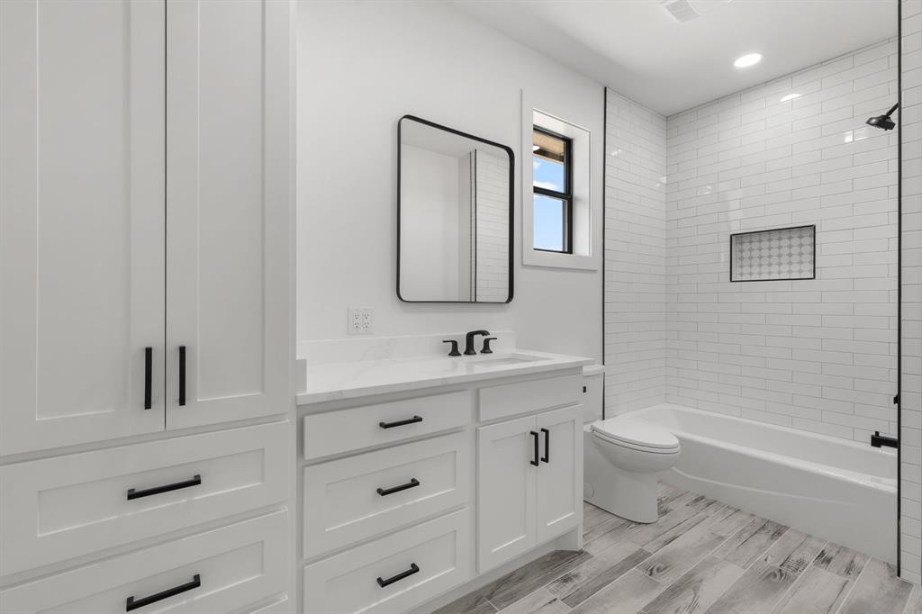 2311 Parker Road Wichita Falls, TX 76310 - Photo 26 of 32 a bathroom with a toilet a sink a tub and mirror