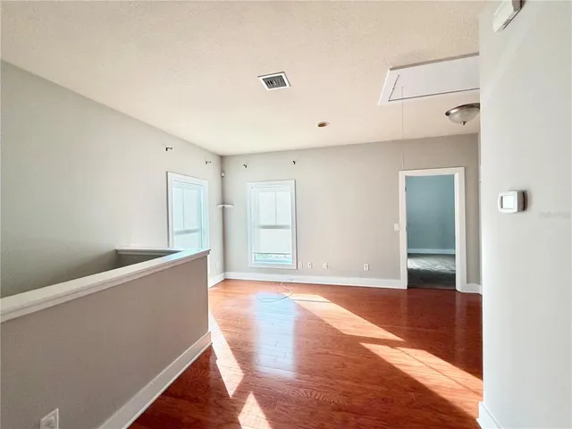 a view of an empty room with wooden floor