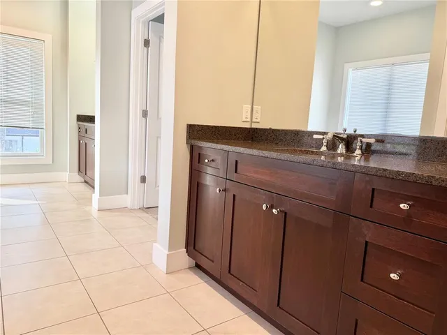 a bathroom with a granite countertop sink a mirror and a vanity