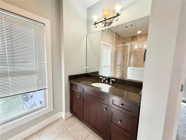 a bathroom with a granite countertop sink and a mirror