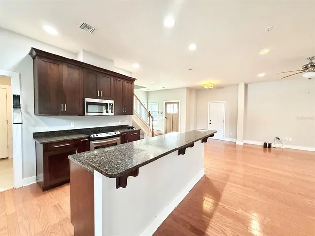 a kitchen with stainless steel appliances granite countertop a sink and a stove