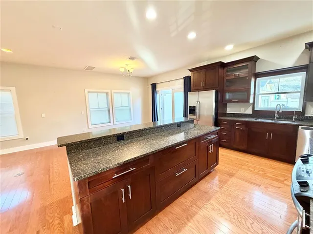 a large kitchen with granite countertop a sink and dishwasher a stove with wooden floor
