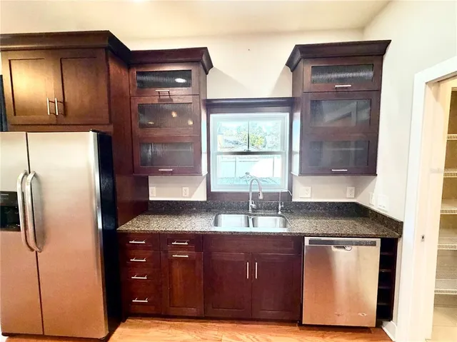 a kitchen with granite countertop stainless steel appliances a refrigerator and stove