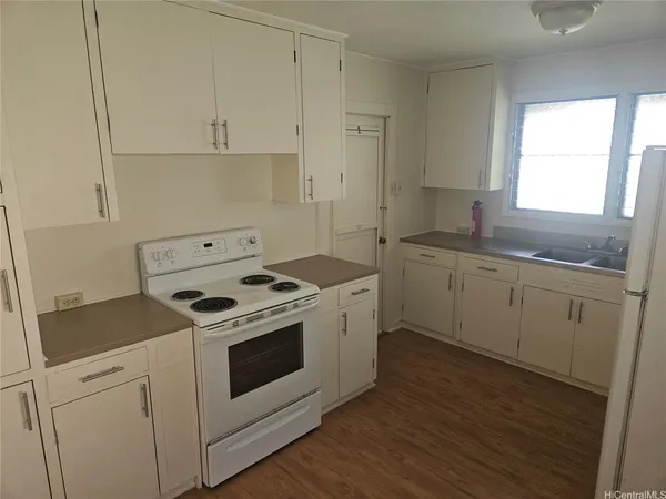 a white stove top oven sitting inside of a kitchen