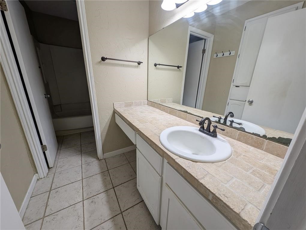 6702 Everhart Road, Unit S104 Corpus Christi, TX 78413 - Photo 14 of 22 a bathroom with a sink a vanity and a mirror