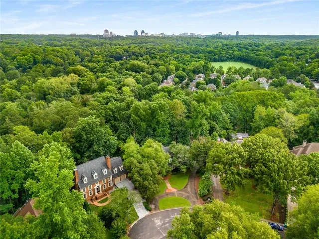 an aerial view of residential house with outdoor space and trees all around