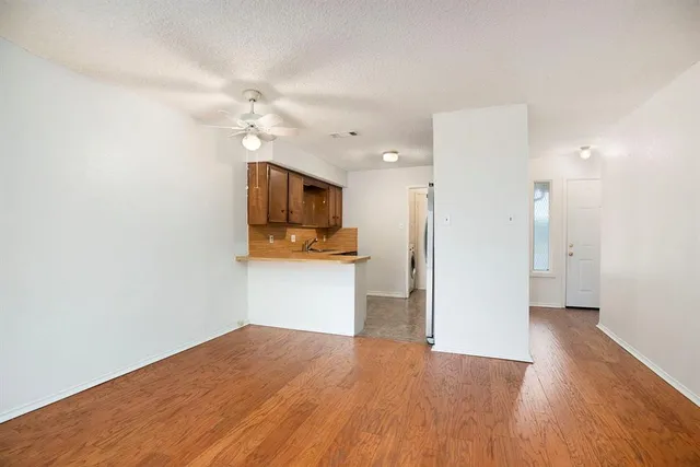 a view of a kitchen with a flat screen tv and wooden floor