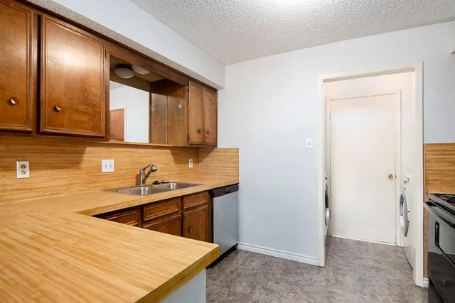 a room with stainless steel appliances kitchen island sink refrigerator and stove