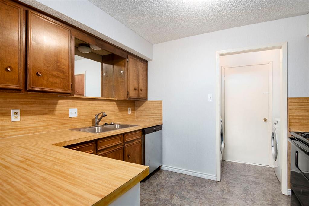 6817 West Cleburne Road Fort Worth, TX 76133 - Photo 13 of 24 a room with stainless steel appliances kitchen island sink refrigerator and stove