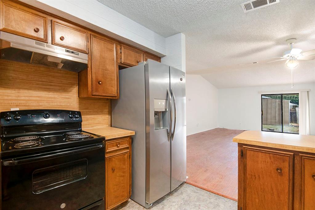 6817 West Cleburne Road Fort Worth, TX 76133 - Photo 14 of 24 a kitchen with stainless steel appliances granite countertop a refrigerator and a stove