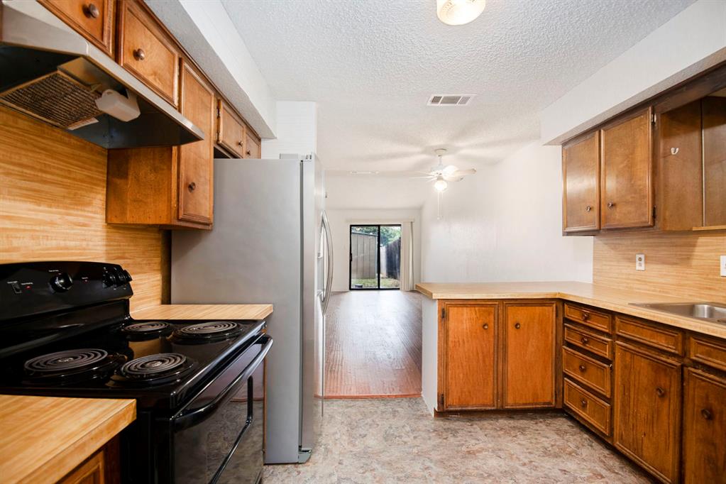 6817 West Cleburne Road Fort Worth, TX 76133 - Photo 15 of 24 a kitchen with stainless steel appliances granite countertop a stove and a sink
