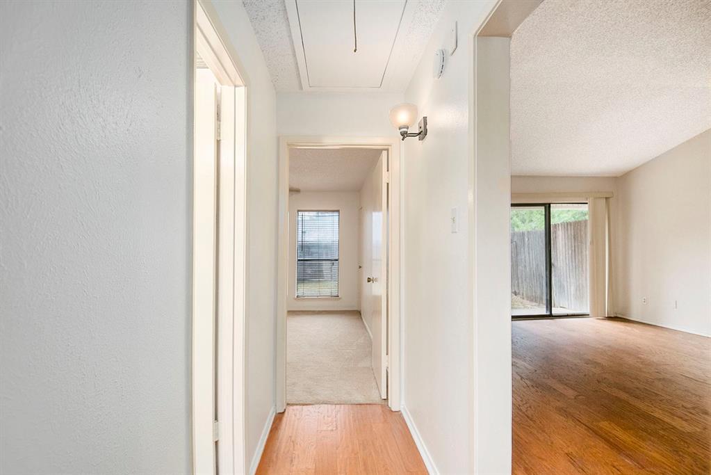 6817 West Cleburne Road Fort Worth, TX 76133 - Photo 17 of 24 a view of a hallway with a chandelier fan and windows